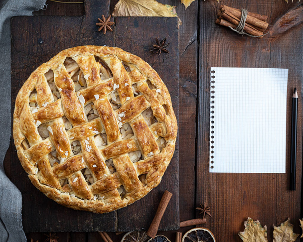 baked whole round apple pie on a brown wooden board, puff pastry - Fotografie, Obrázek