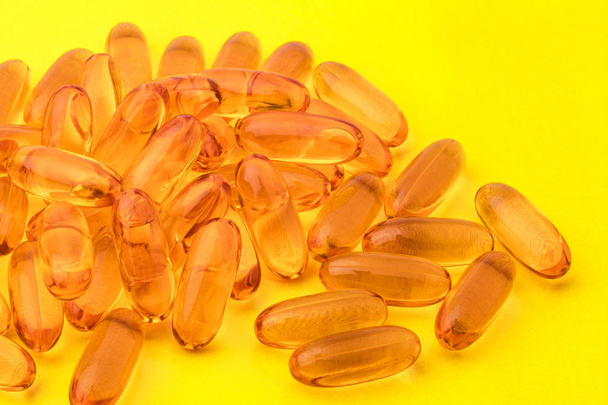 Omega 3 capsules from fish oil on a yellow background. Copy space  - Zdjęcie, obraz