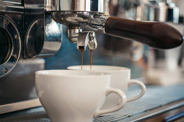 バリスタ スタイルのコーヒーをお楽しみください。喫茶店やカフェで醸造されるコーヒー。Portafilter とエスプレッソ。コーヒー カップ。ホットド リンクを提供する小さなカップ。エスプレッソ マシンでコーヒーを醸造 - 写真・画像