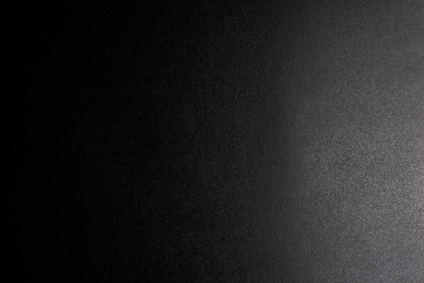 Nero, ruvido sfondo strutturato illuminato con luce fioca
. - Foto, immagini
