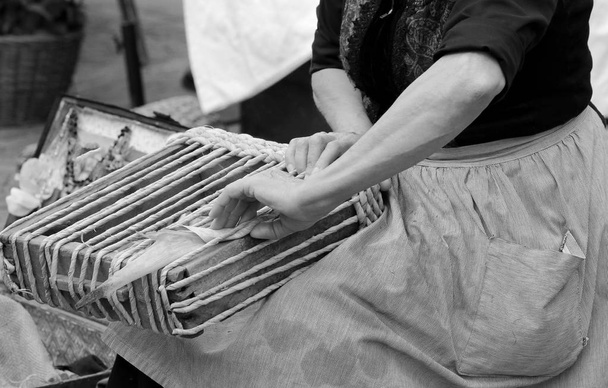 vrouw die met haar handen werkt omwonden de druppel om te maken een prachtige handgemaakte tas - Foto, afbeelding