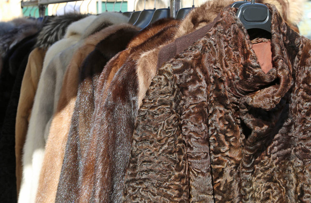 fur coats and clothes in the hanger in the market - Photo, Image