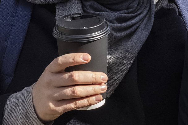 paper cup of coffee in the hand. Black paper cup of coffee in hand. Copy space - Fotó, kép