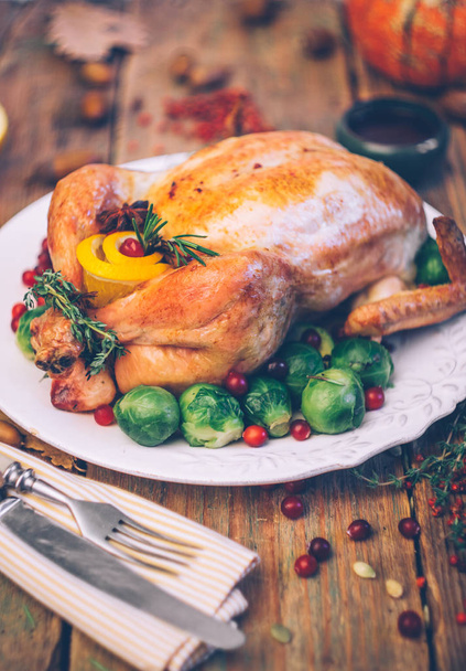 Karácsonyi sült csirke, kelbimbó és a fűszereket egy rusztikus, fából készült asztal. Karácsonyi vacsora, vagy őszi vacsora koncepció háttér őszi levelek. Karácsonyi táblázat beállítása háttérben. - Fotó, kép
