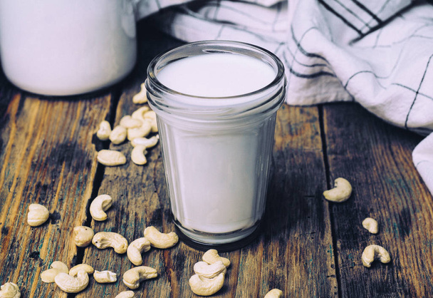 Fresco biologico crudo latte vegan anacardi con anacardi su sfondo wodden
. - Foto, immagini