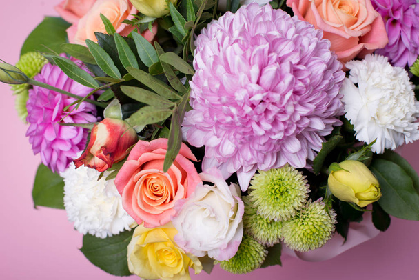 ボックス、ピンクと黄色のバラ、美しいフラワーアレンジメント ピンクのトルコギキョウ、緑菊、テキスト用のスペースとピンクの背景に白いカーネーション、ピンクのダリア - 写真・画像