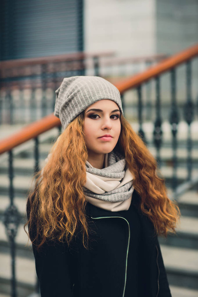 Portrait of funny young girl in the autumn weather in warm clothes and hat. - Foto, afbeelding