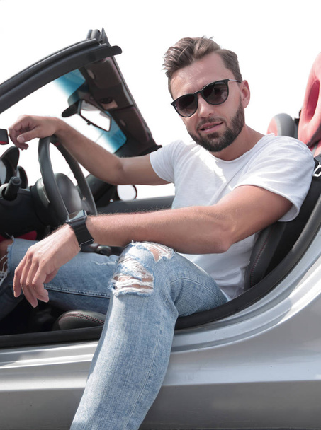 close up.stylish young man sitting in a luxury car - 写真・画像