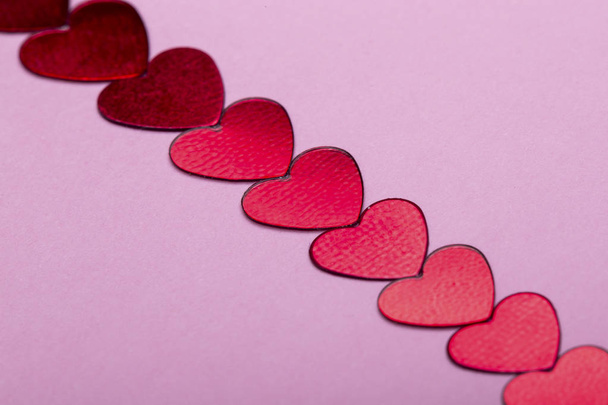 μικρά διακοσμητικά κόκκινες καρδιές σε ροζ φόντο - Φωτογραφία, εικόνα