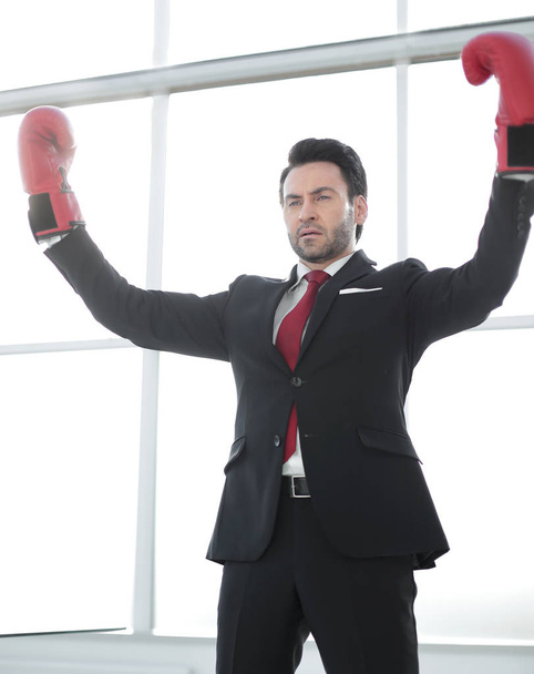 close up. businessman in Boxing gloves shows a gesture of victory - Фото, изображение
