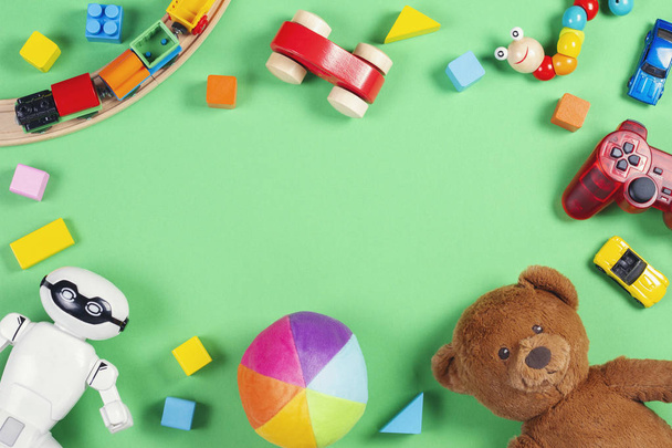 Marco de juguetes para niños bebé con oso de peluche, coches de juguete, robot, ladrillos de colores, cubos sobre fondo rosa
 - Foto, imagen