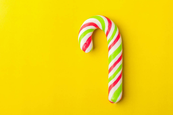 Christmas Candy Cane with colorful Bow on yellow Background. Copy space   - Foto, immagini