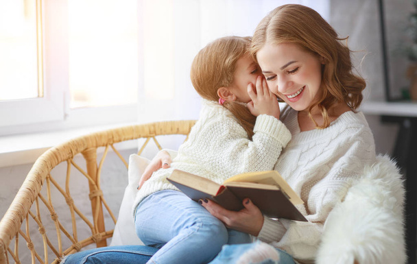 happy family mother reads book to child to daughter by window in winter mornin - Photo, Image