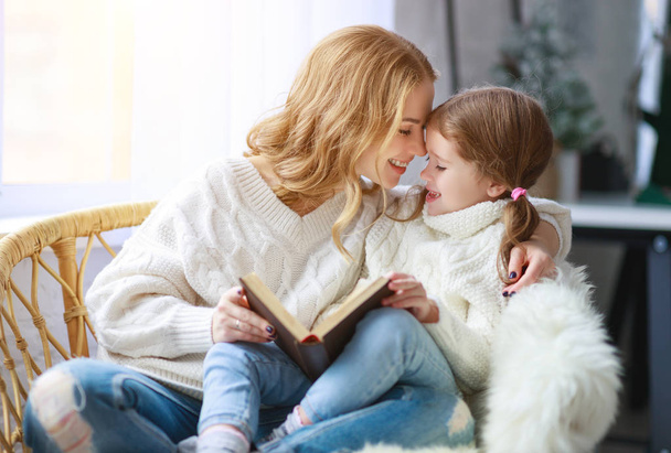 boldog család anya elolvassa a könyvet, a gyermeket, hogy lánya ablak a téli jó reggelt - Fotó, kép