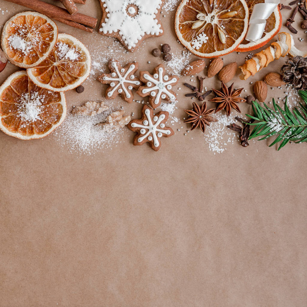 Christmas decoration with spices and cookies in the shape of snowflakes on dark brown paper background. Top view. - Fotografie, Obrázek