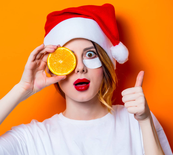 Mulher usando remendo de olho para os olhos no chapéu de Papai Noel com fundo de citro isolado. Retrato de mulher natural e verdadeira como geralmente são parece
 - Foto, Imagem