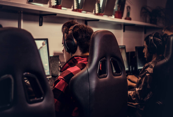 Equipo de jugadores adolescentes juega en un videojuego multijugador en PC en un club de juegos
. - Foto, imagen