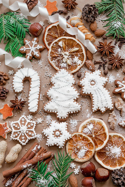 Christmas decoration with spices and cookies in the shape of snowflakes on dark brown paper background. Top view. - Fotografie, Obrázek