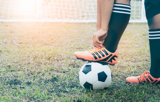 Foot of a soccer player in a football boot on a ball on an green lawn of the stadium - Photo, Image