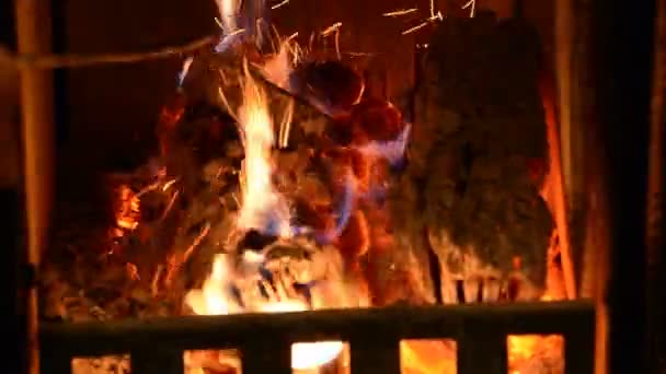 Ajuste manual de troncos con gancho de hierro largo para que se pueda quemar intensamente. Troncos ardiendo en casa dentro de la chimenea. Chimenea cubierta abierta que quema y calienta la sala de estar. Primer plano, enfoque selectivo
 - Imágenes, Vídeo