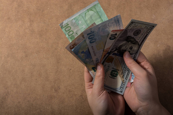 Kézben tartott amerikai dollár bankjegyek elszigetelt fa háttér - Fotó, kép