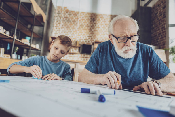 Concentrated pensioner drawing straight line - Foto, Bild