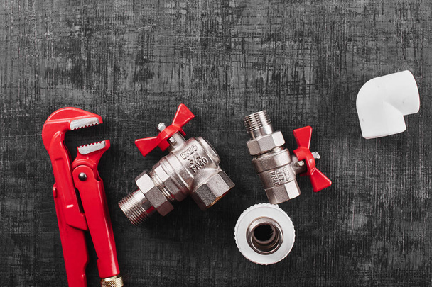 plumbing tools and equipment on black shabby background, close-up - Foto, Bild