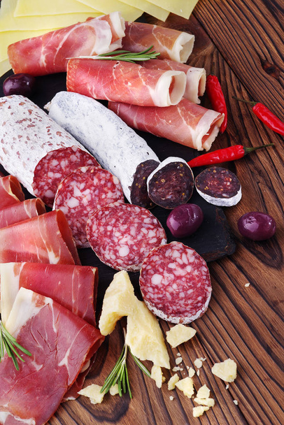 Delicacy meat platter of jamon and jerked sausage fuet on a wooden table. - Foto, immagini