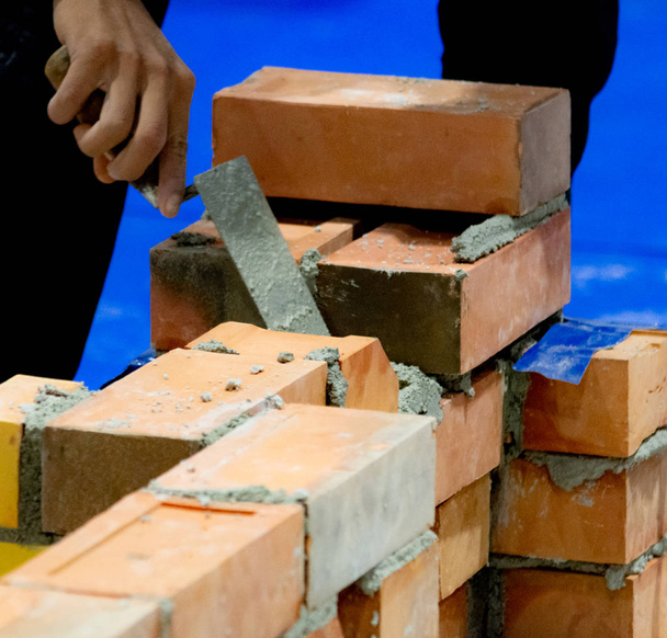 Bricklayer asentamalla tiilet, Bricklayer työntekijä asentamalla tiili muuraus ulkoseinään lastalla kitti knif
 - Valokuva, kuva