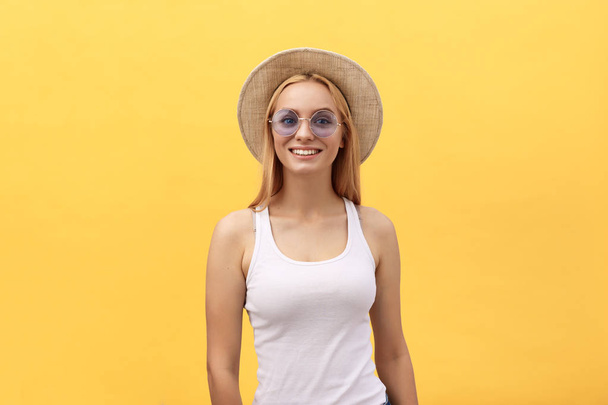 Щаслива стильна сучасна жінка з сучасними сонцезахисними окулярами сміється, дивлячись на вас фотоапарат ізольовано на жовтому тлі. Концепція щастя
 - Фото, зображення