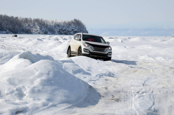 Jeep gaat door oneffen ijs met getroubleerd en hobbels van het Baikalmeer - Foto, afbeelding