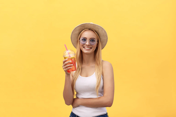 Heureuse femme moderne et élégante avec des lunettes de soleil modernes en forme de rire en vous regardant appareil photo isolé sur fond jaune. Concept de bonheur
 - Photo, image