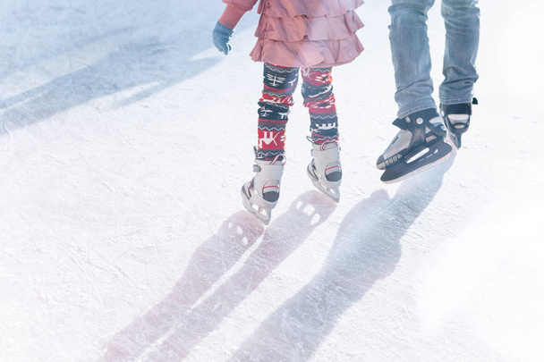 Father and daughter skate on the rink during the winter holidays. - Φωτογραφία, εικόνα