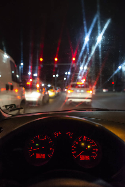 Car dashboard and window at night. Traffic lights - Foto, afbeelding