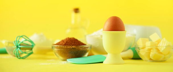 Healthy baking ingredients - butter, sugar, flour, eggs, oil, spoon, rolling pin, brush, whisk, milk over yellow background. Banner. Bakery food frame, cooking concept. Copy space - Zdjęcie, obraz