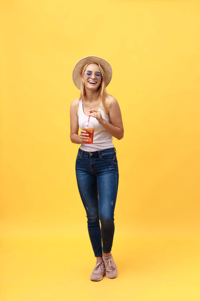 Retrato de comprimento total de uma jovem alegre vestindo roupas de verão enquanto posando e olhando para a câmera isolada sobre fundo de verão amarelo
 - Foto, Imagem
