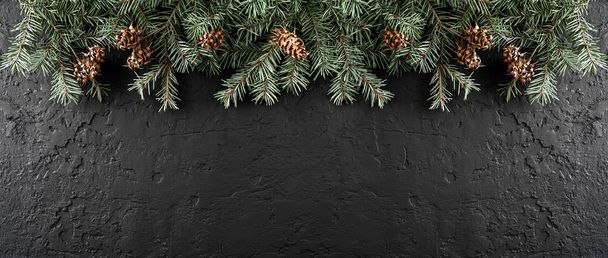 Vánoční jedle větve a šišky na tmavém pozadí s sněhové vločky. Téma Vánoce a nový rok. Plochá ležel, horní pohled, prostor pro text, širokou skladbu - Fotografie, Obrázek