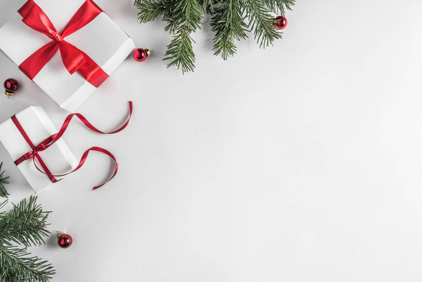 Luova runko joulukuusen oksat valkoisella paperilla taustalla punainen koristelu, mänty käpyjä. Joulun ja uudenvuoden teema. Tasainen, ylhäältä
 - Valokuva, kuva