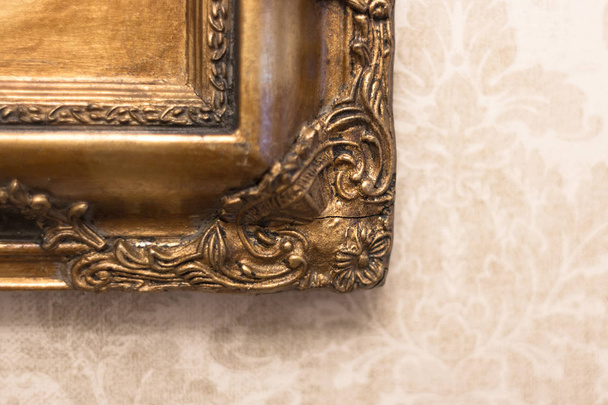 Gilded frame. Old picture. Expensive vintage mirror. Crack on an antique frame. Rare decor in the design of a luxurious interior. Restoration of a frame with an ornament. - Foto, Bild