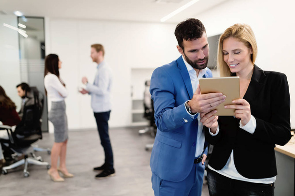 Young attractive business couple using tablet in their company - Photo, Image