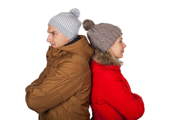 Young couple wearing red and brown winter parka jacket posing on isolated background - Seasonal fashion clothing - Foto, imagen