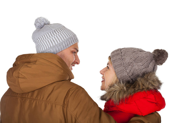 Young couple wearing red and brown winter parka jacket posing on isolated background - Seasonal fashion clothing - 写真・画像