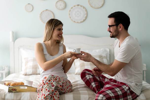 Foto de pareja joven y feliz pasando la mañana juntos en el dormitorio
 - Foto, Imagen