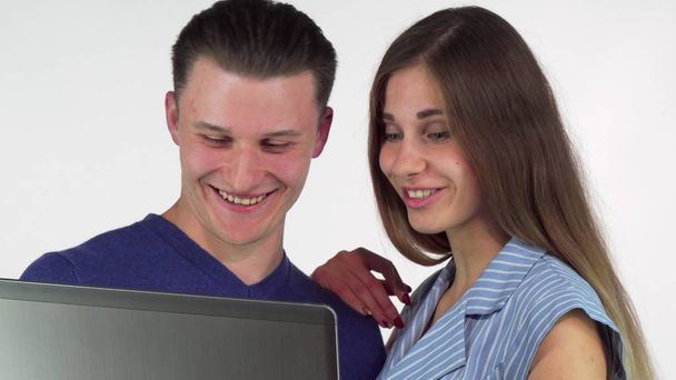 Onnellinen pari käyttää kannettavaa tietokonetta yhdessä, hymyillen iloisesti
 - Valokuva, kuva
