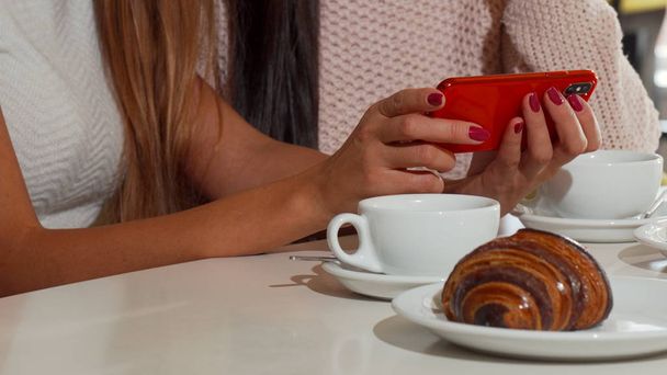Schöne Freundinnen mit Smartphone im Café - Foto, Bild