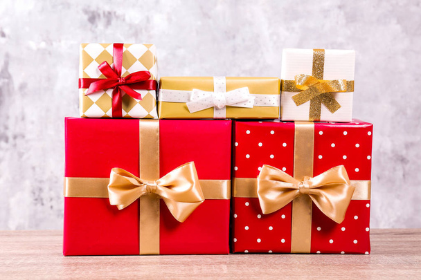 Christmas preparation concept. Stack of different colorful presents for every family membet. Pile of gifts in bright festive wrapping. Close up, copy space grunged concrete wall background. - Photo, image