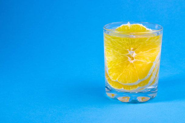 lemonade in a clear glass with orange, orange drink - Fotó, kép