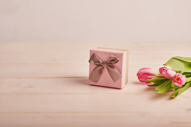розовая подарочная коробка с цветами на светлом фоне
 - Фото, изображение