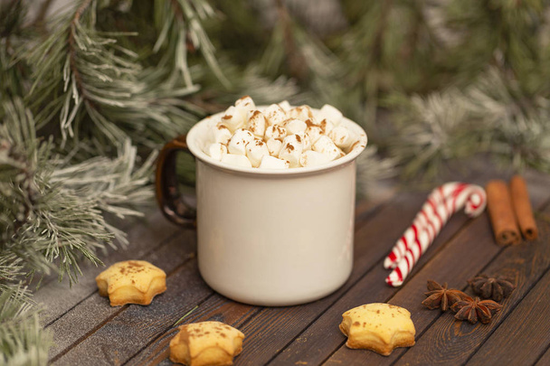 Winter hot Christmas chocolate or cocoa with marshmallow with decorations. A cup of hot chocolate with marshmallows and gingerbread on a Christmas table. - Photo, Image