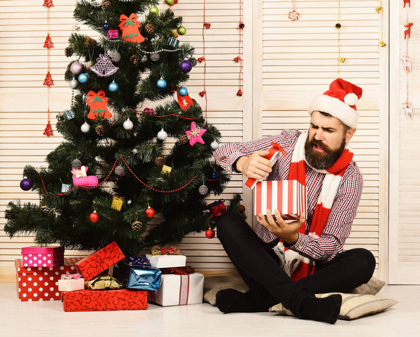 Santa Claus with disappointed face on red garlands background - Photo, image